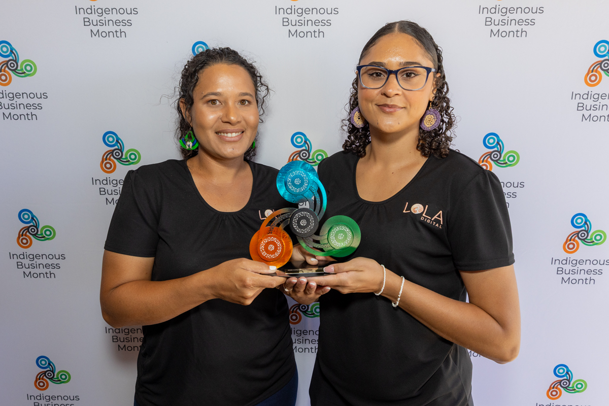 Two girls hold up their award