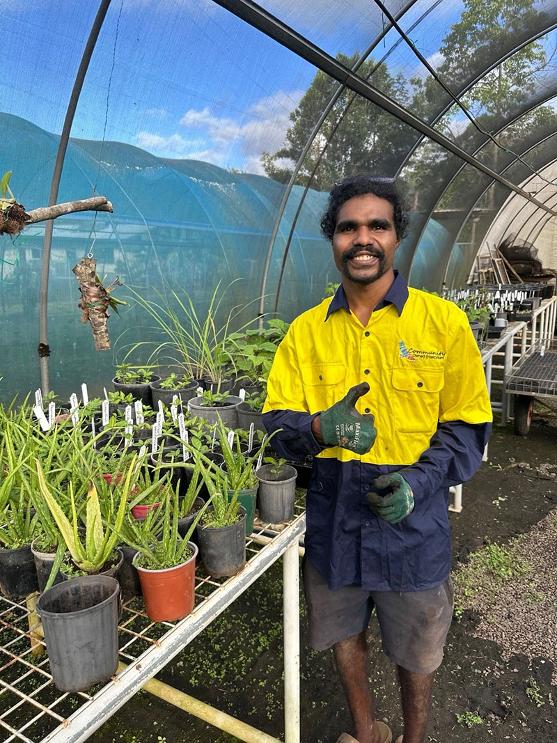 A worker gives the thumbs up inside a greenhouse