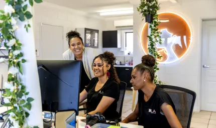 3 girls work in an office looking at the same screen