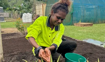 A woman pouring water on a plant