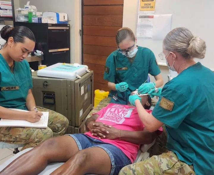 Three army dentists working on a patient