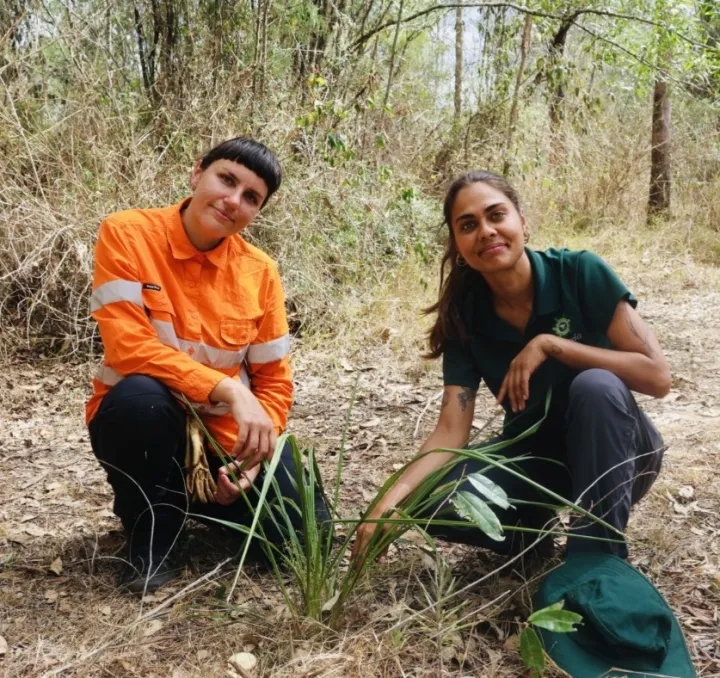 Indigenous Rangers Lucinda Landers and Shoshana William with native Blue Dianella Flax Lilly  